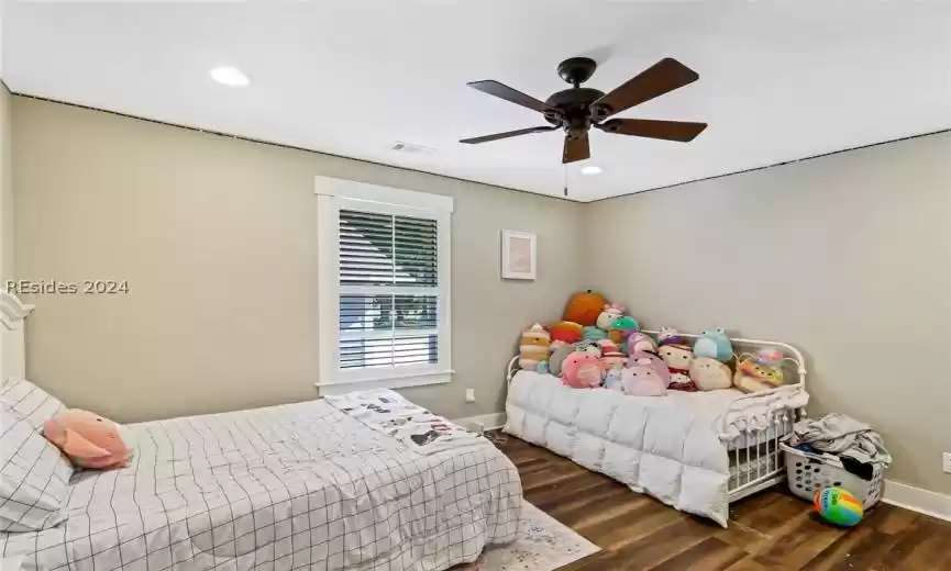 Guest Bedroom with dark hardwood / wood-style flooring and ceiling fan