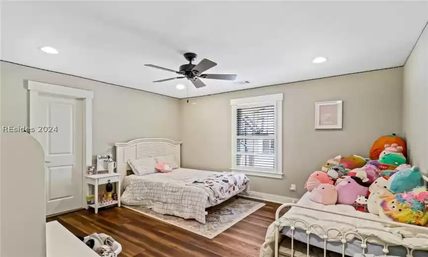 Guest Bedroom with dark hardwood / wood-style flooring and ceiling fan