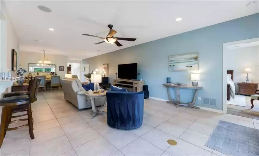 Large open living area with the kitchen on the left and primary bedroom on the right