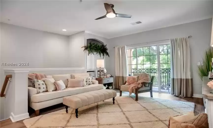 Living room with ceiling fan, light hardwood / wood-style floors, and crown molding