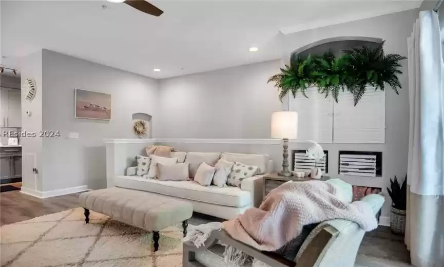 Living room featuring ceiling fan and dark hardwood / wood-style flooring