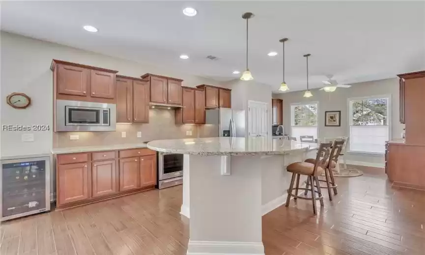 Gorgeous wood floors,  large island and granite countertops in the kitchen