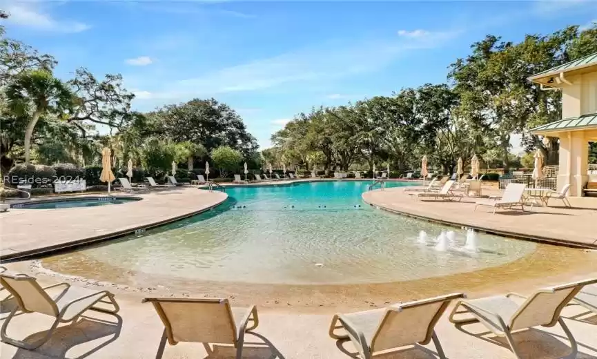 View of swimming pool with a patio area and a hot tub