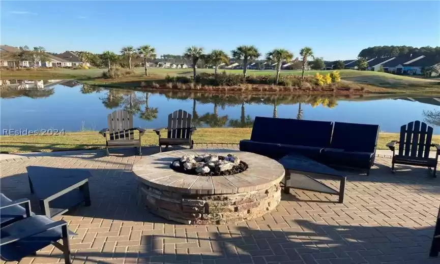 View of terrace featuring a fire pit and a water view