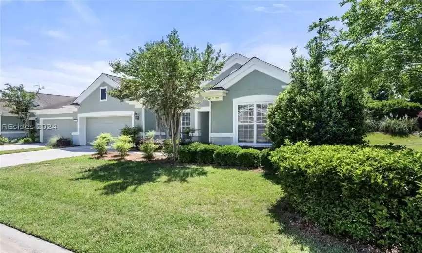 Mature landscaping grace the entrance to this Wren villa.