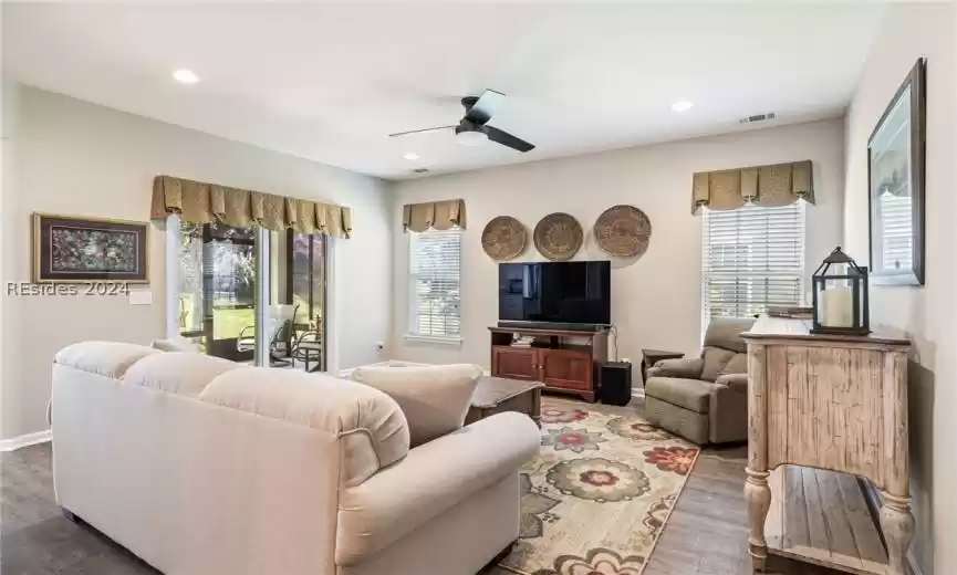 Living area is highlighted by neutral colors and attractive ceiling fan and window coverings.