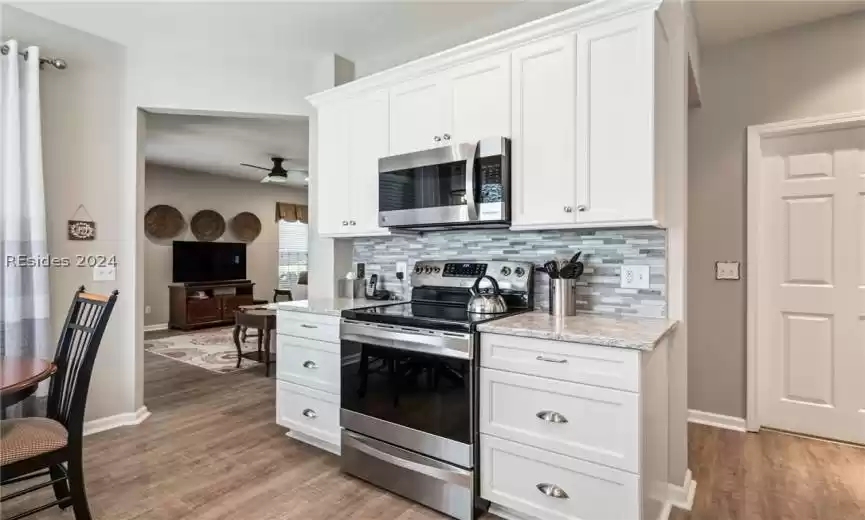 Kitchen has new white cabinets, quartz counter tops with tile backsplash.