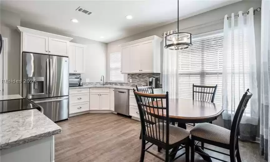 Eat in kitchen has attractive light above breakfast table.