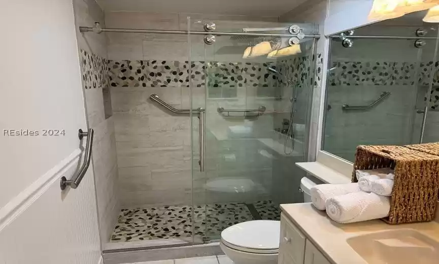 Walk-in shower with spa shower head and natural stones.
