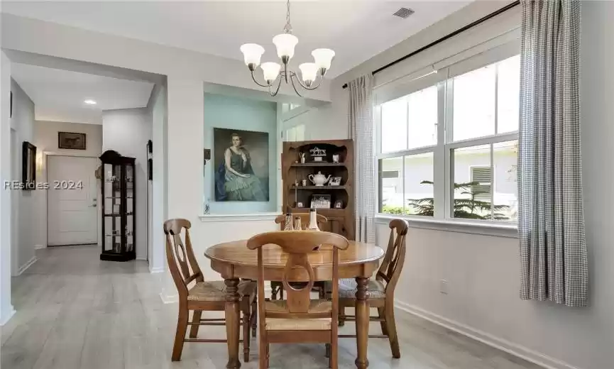 Dining area featuring light hardwood / wood-style floors and a notable chandelier