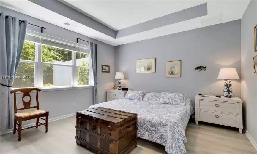 Bedroom with a raised ceiling and hardwood / wood-style floors