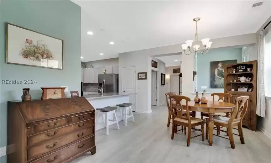 Dining space with a notable chandelier and light hardwood / wood-style flooring