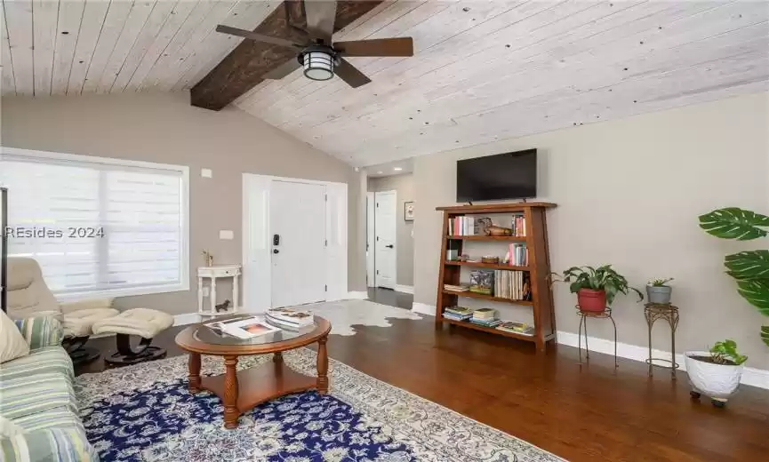 Living room featuring wood-type flooring, wood ceiling, ceiling fan, and vaulted ceiling with beams