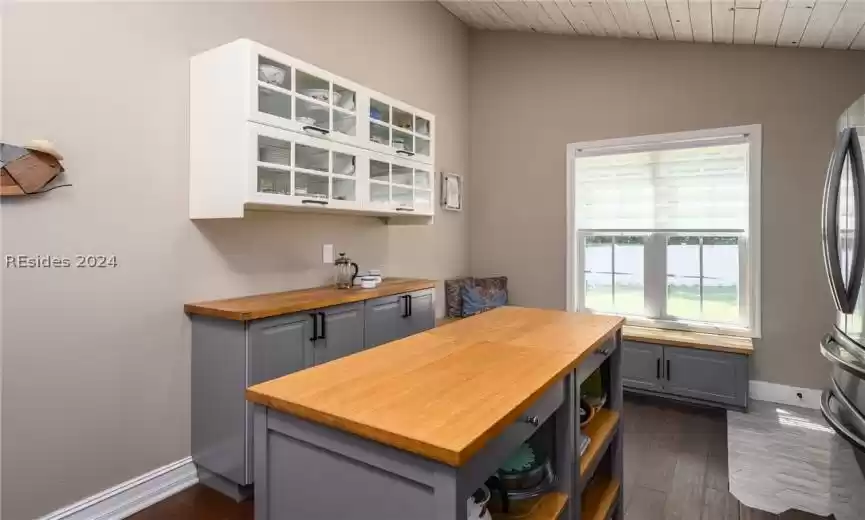 Kitchen with wood counters, gray cabinets, and dark wood-type flooring