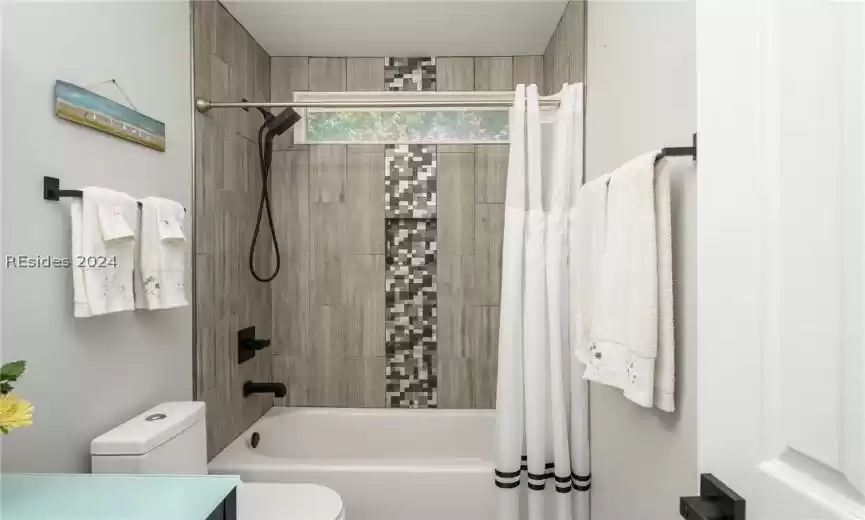 Second bathroom featuring shower / tub combo and toilet