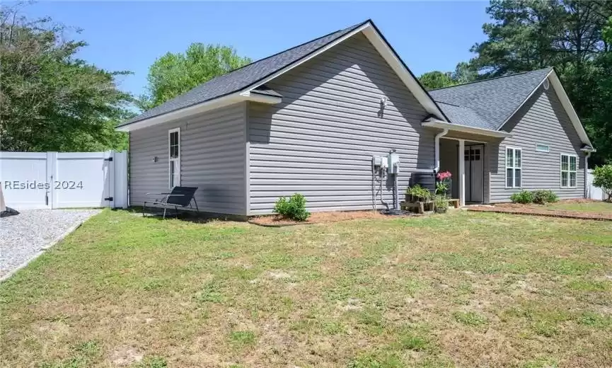 View of side of property featuring backyard and gravel space to park